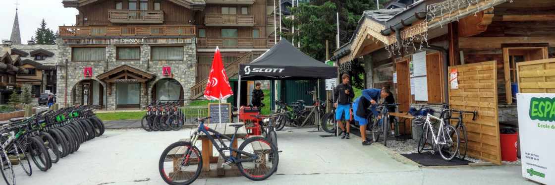 Een bonte verzameling huurfietsen van VTT Espace in Courchevel Tientallen fietsen staan opgesteld bij Espace VTT