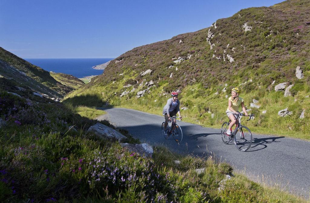 De zee is nooit ver weg op route... twee fietsers vlak bij Maiin Head in Ierland
