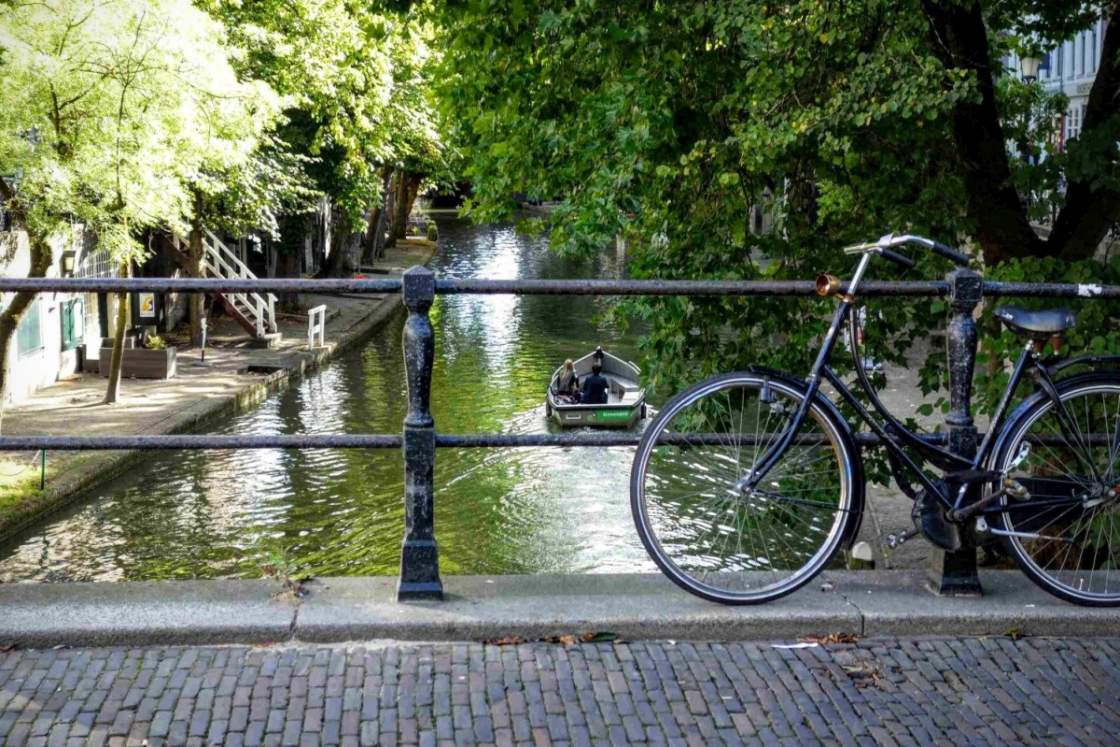 Oudegracht met de befaamde werfkelders Foto van fiets op een bruggetje en een bootje bij de Oudegracht