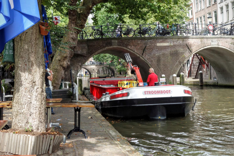 De 'Zuipschuit' aan het werk in hartje Utrecht De Bierboot van Utrecht laadt kratjes bier uit aan de Oudegracht
